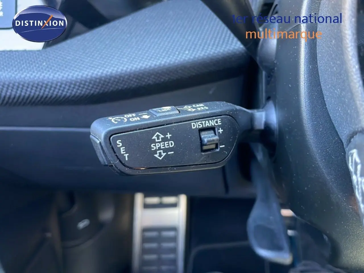 Gros plan sur la commande de régulateur de vitesse au volant d’un Audi A3 Sportback bleu Navarre 2025.