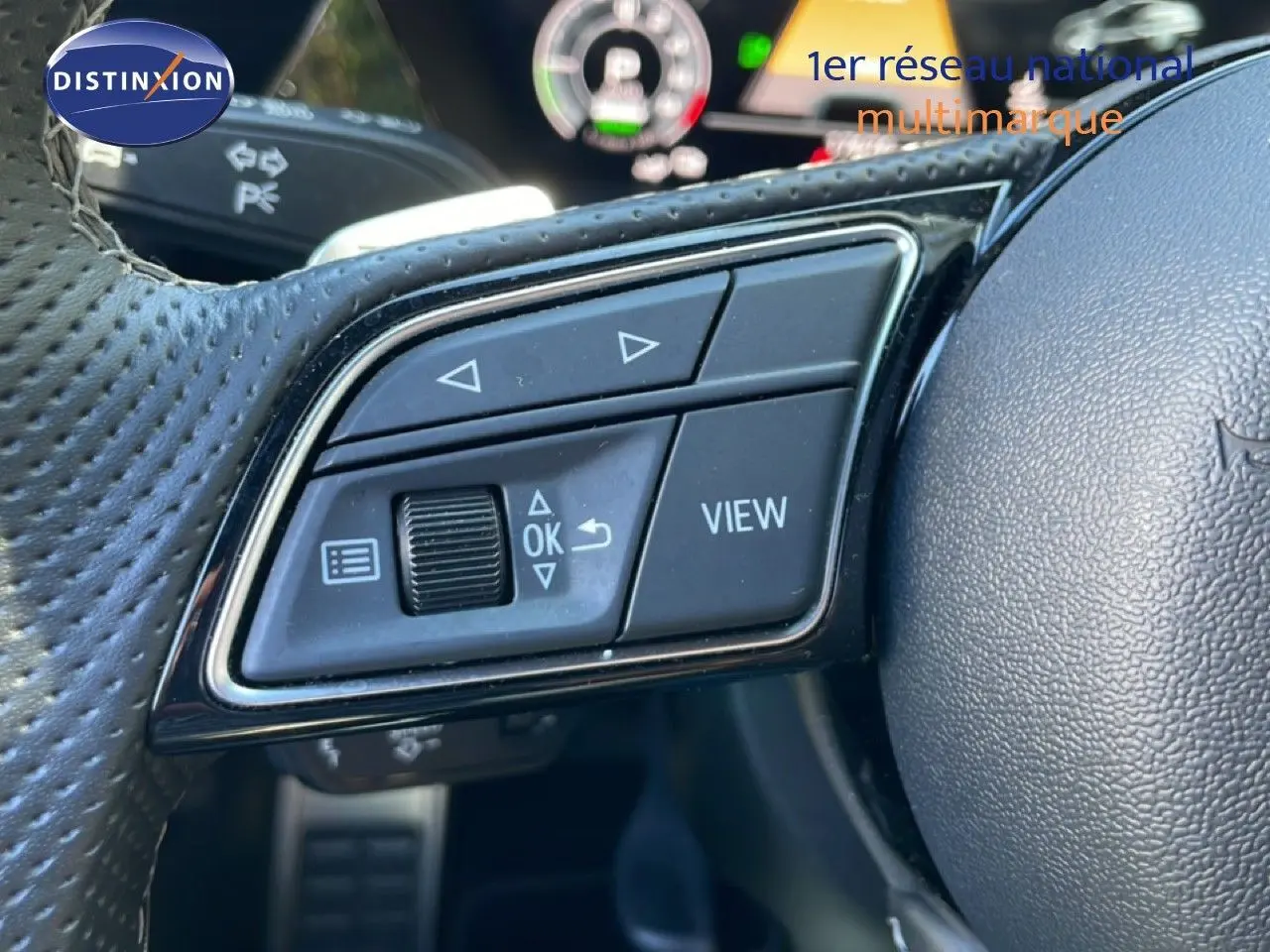 Gros plan sur les commandes multifonctions à gauche du volant en cuir perforé de l'Audi A3 Sportback 2025.