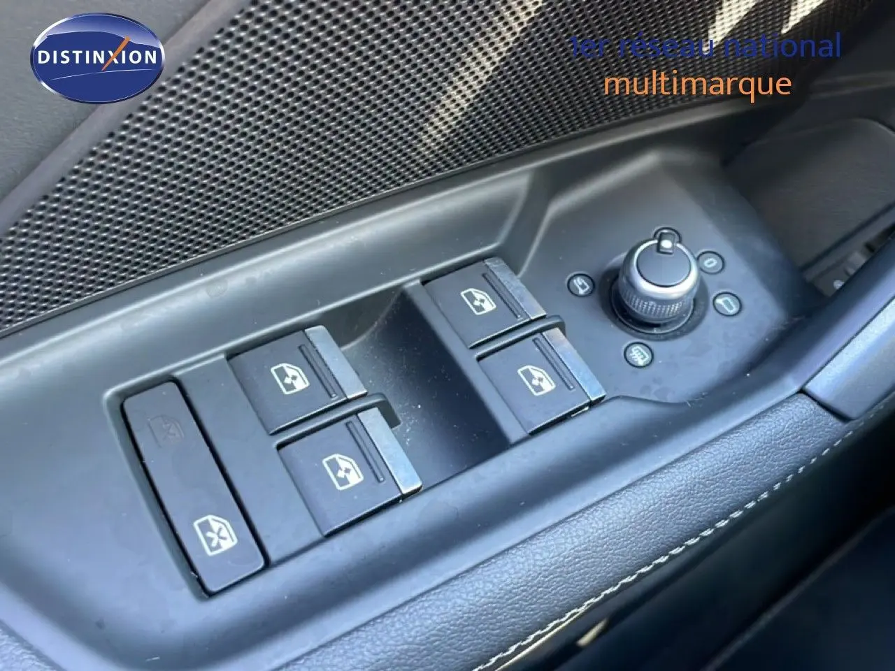 Gros plan sur les commandes des vitres électriques et rétroviseurs côté conducteur de l'Audi A3 Sportback bleu Navarre 2025.