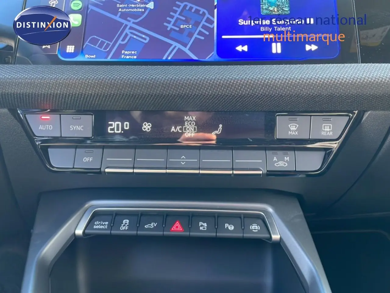 Vue rapprochée du tableau de bord de l’Audi A3 Sportback 2025, mettant en valeur les commandes climatisation et fonctions hybrides.
