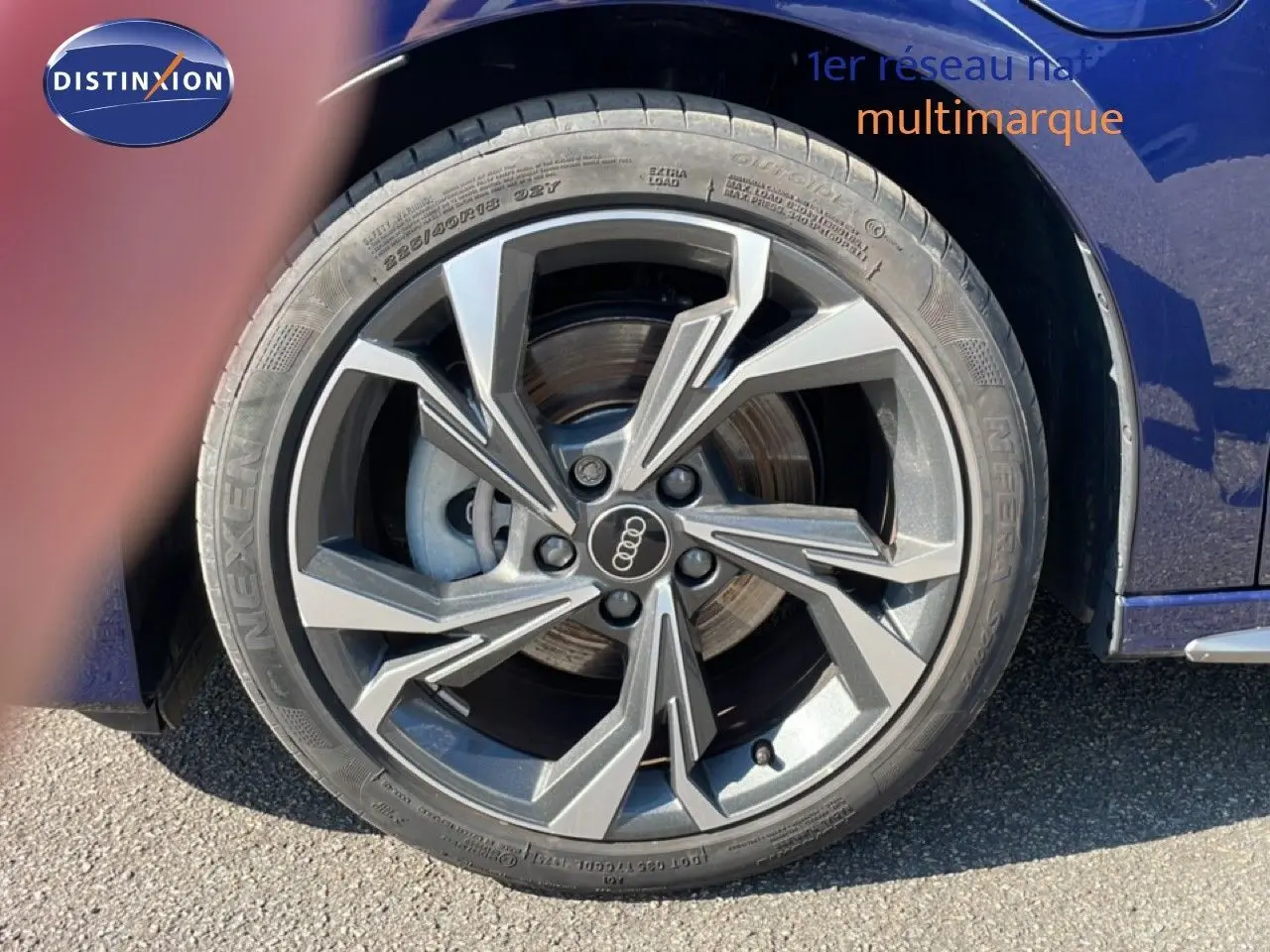 Gros plan sur la roue avant droite d'une Audi A3 Sportback bleu Navarre métal avec jante alliage distinctive.