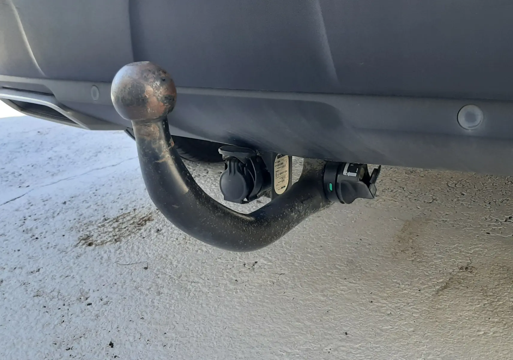 Gros plan sur l'attelage d'une Peugeot 3008 bleu Vertigo avec toit noir, vu à l'arrière sous le pare-chocs.