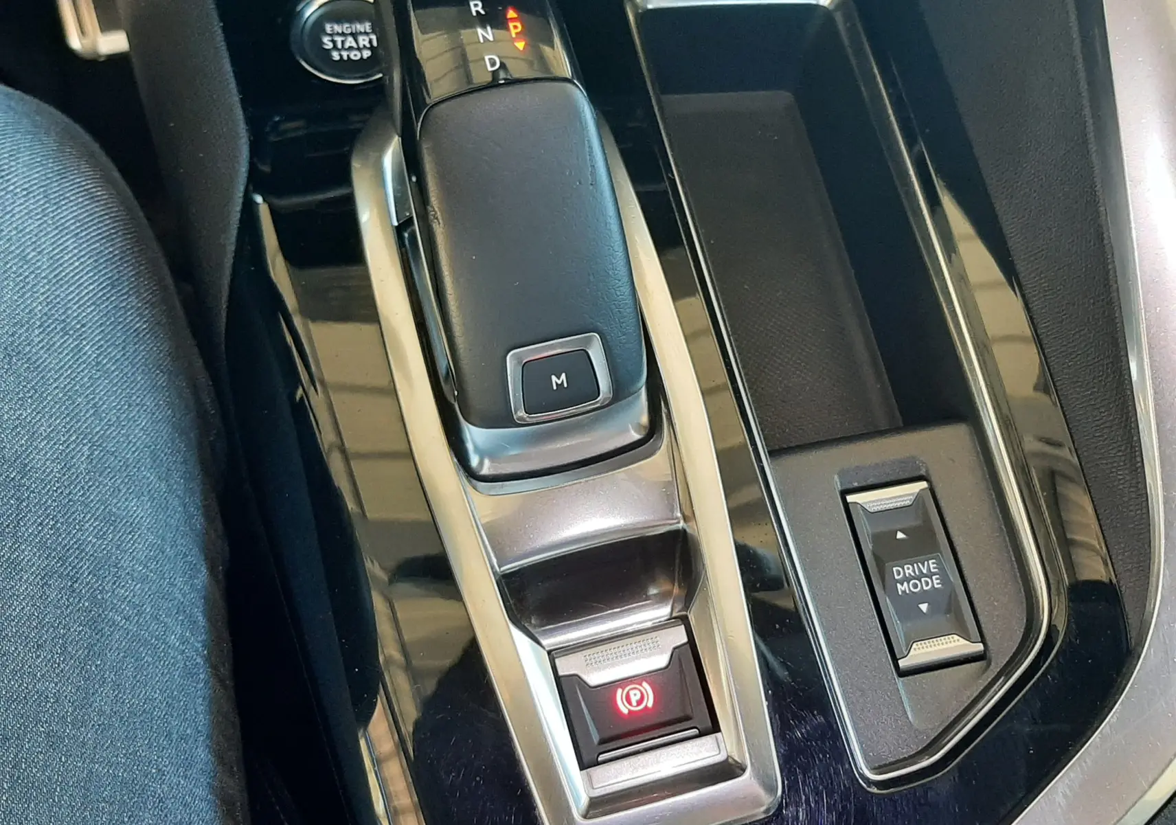 Vue rapprochée de la console centrale noire du Peugeot 3008 2023, avec levier de vitesse automatique et bouton Drive Mode.