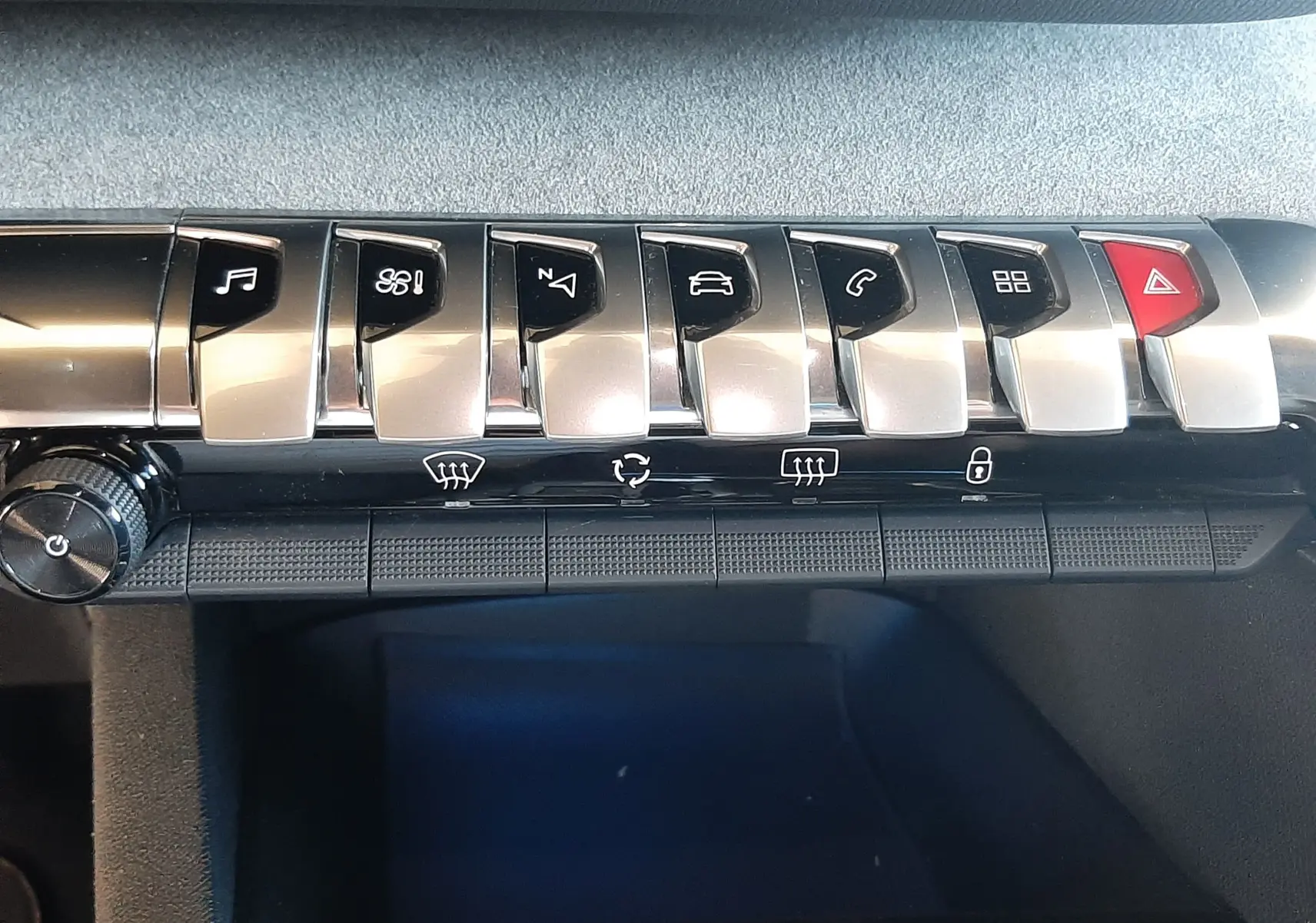 Gros plan sur la rangée de boutons piano en métal brossé du tableau de bord du Peugeot 3008 2023.