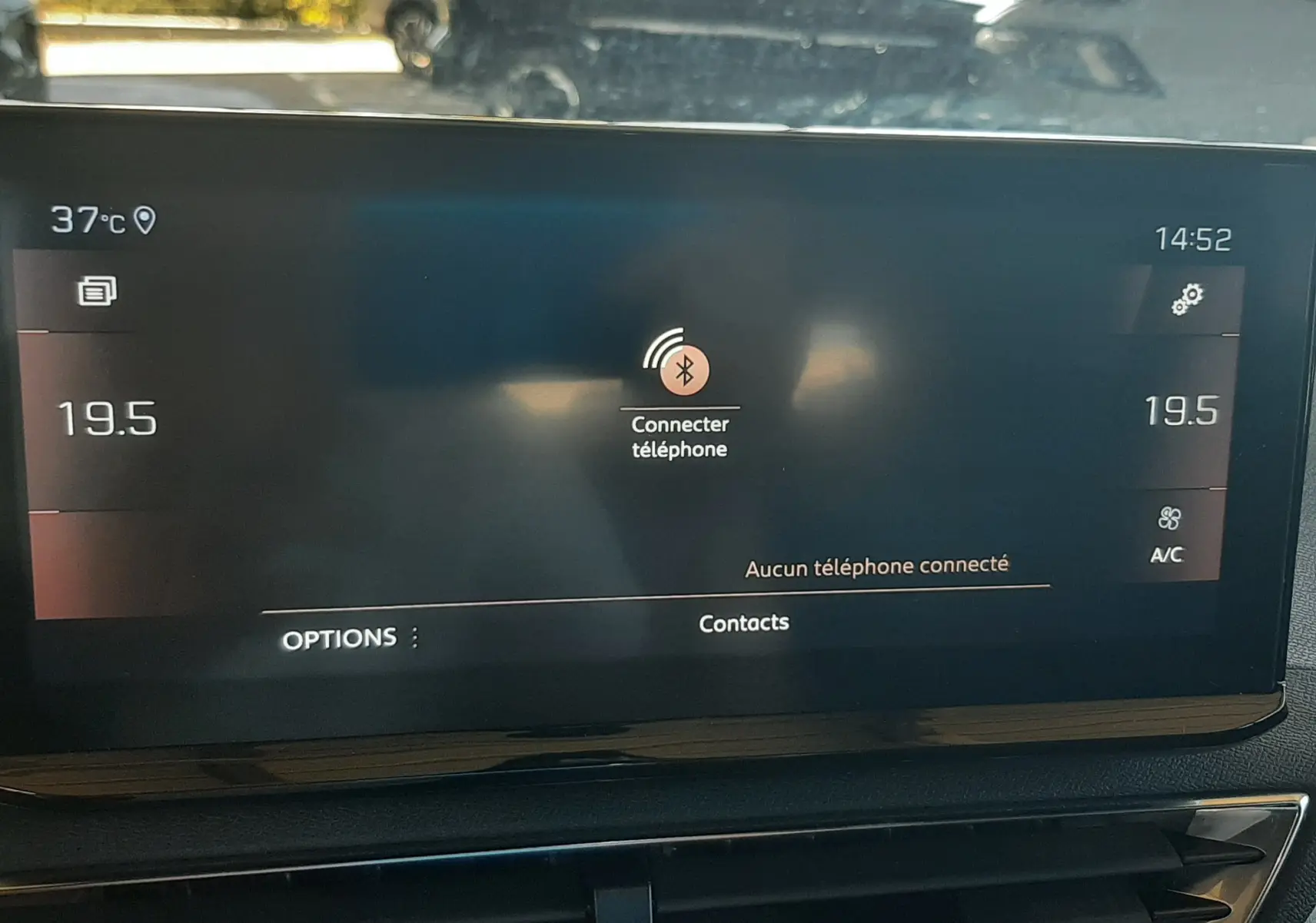 Écran tactile central du Peugeot 3008 2023 affichant la connexion Bluetooth, avec vue floue sur véhicules extérieurs.