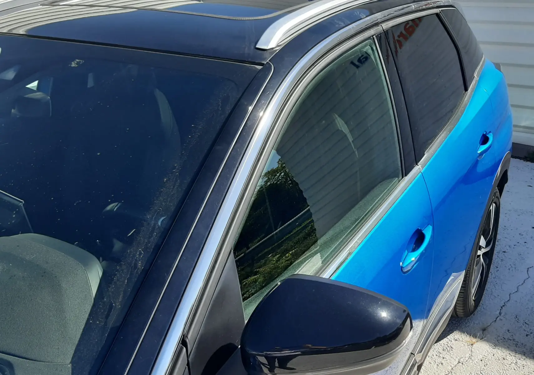 Vue 3/4 avant droit du Peugeot 3008 bleu Vertigo avec toit noir brillant et rétroviseur noir.