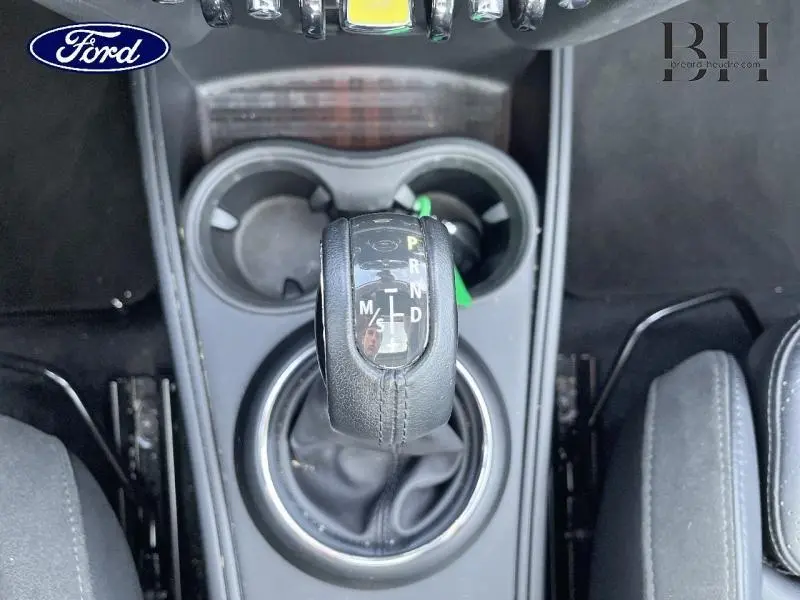 Le levier de vitesses automatique en cuir noir de la MINI Countryman Cooper SE vu de dessus entre les sièges avant.