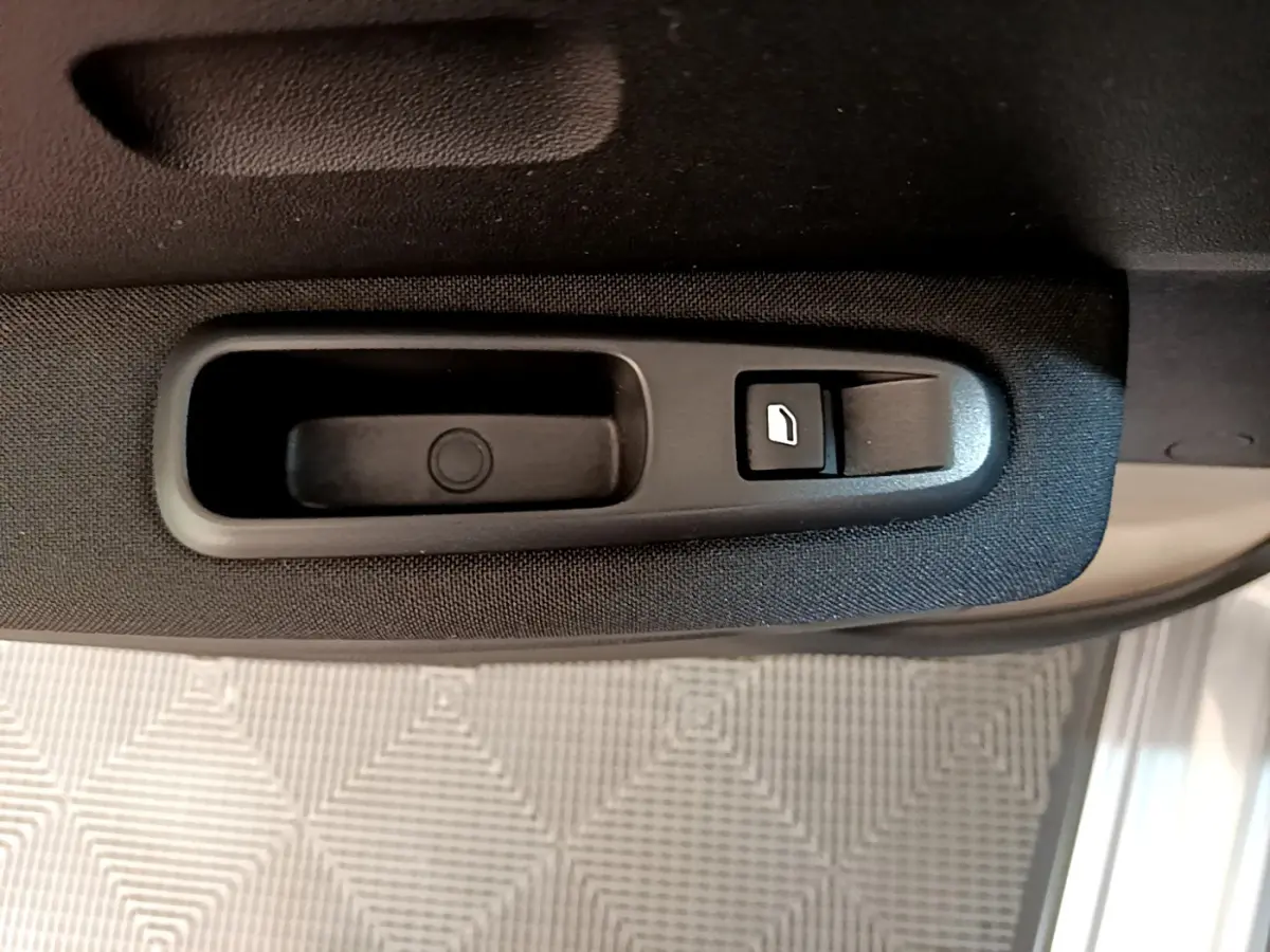 Gros plan sur la commande de lève-vitre côté conducteur d'une Citroën C3 gris clair de 2019.