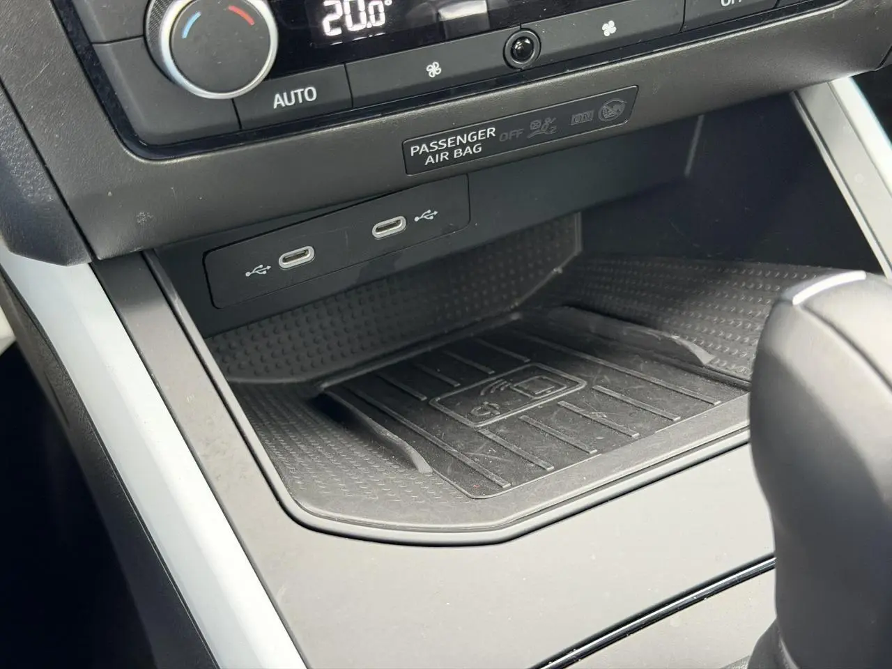 Détail de la console centrale du SEAT Arona 2025 avec zone de recharge sans fil et ports USB-C sous la climatisation.
