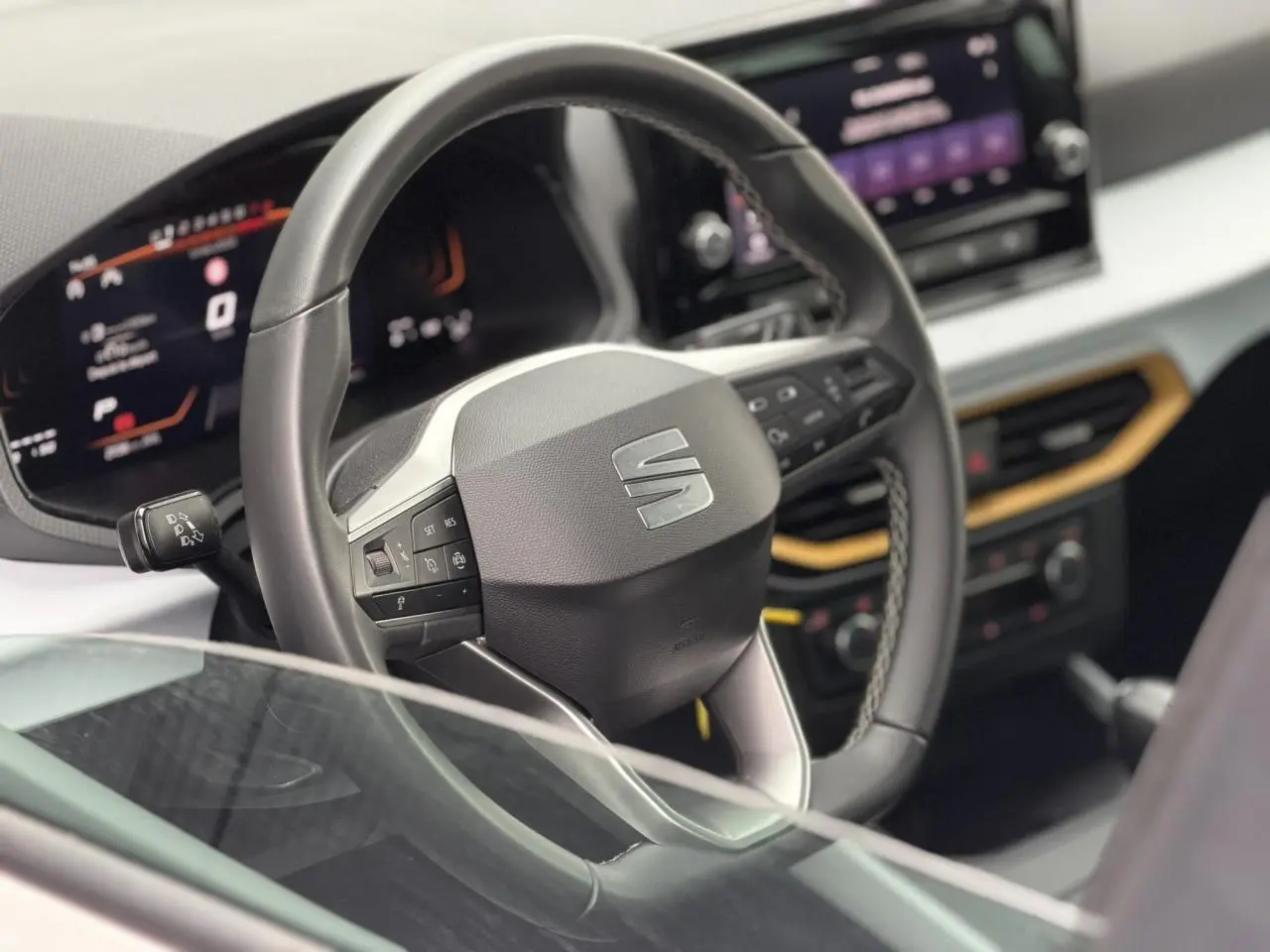Vue rapprochée du volant et du tableau de bord digital du SEAT Arona TSI 115 DSG Style avec écran tactile et finitions modernes.