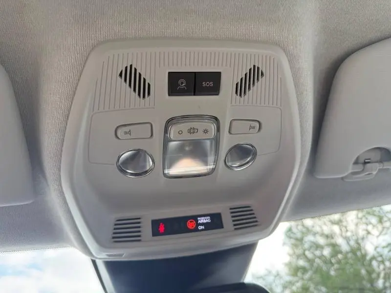 Vue en gros plan du plafonnier intérieur gris clair du Citroën C3 2025 noir, avec boutons SOS et éclairage.