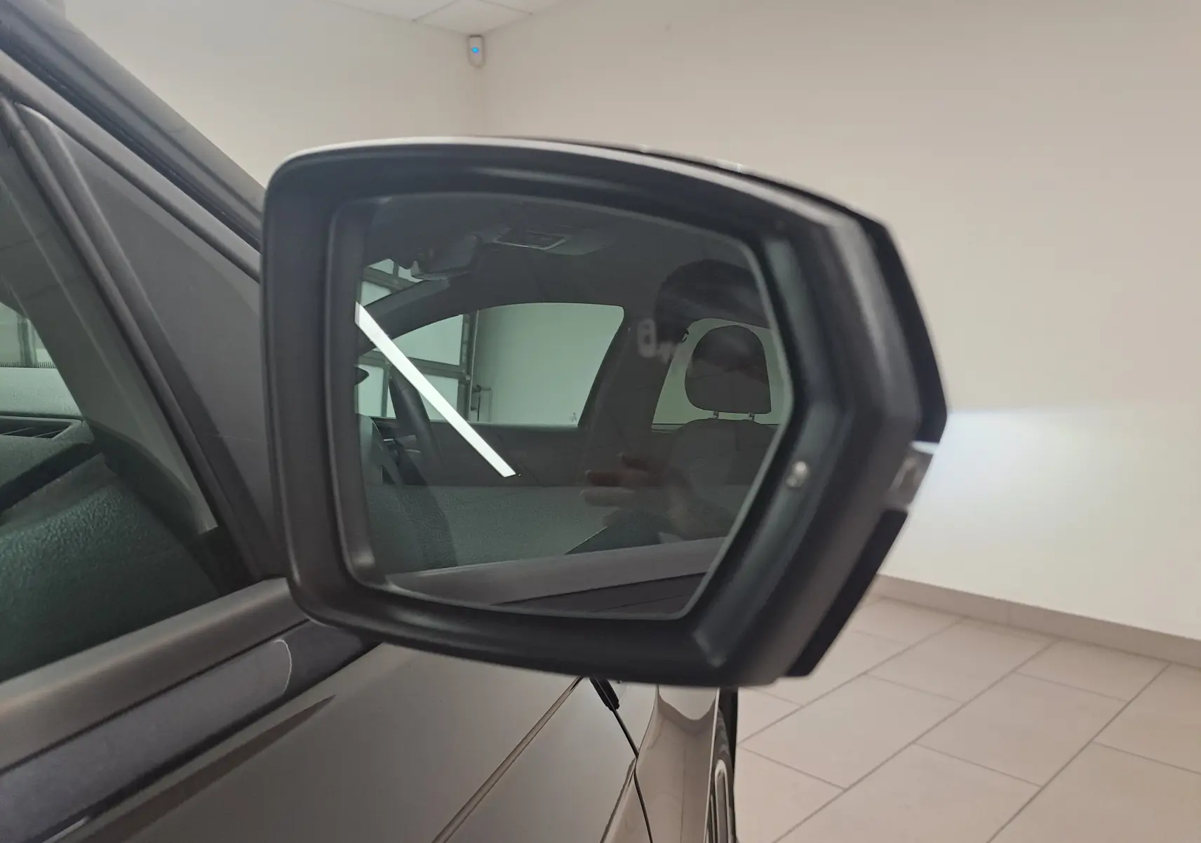 Rétroviseur extérieur côté gauche d'une Volkswagen Polo 1.0 TSI 95 R-Line noir intense, intérieur partiellement visible.