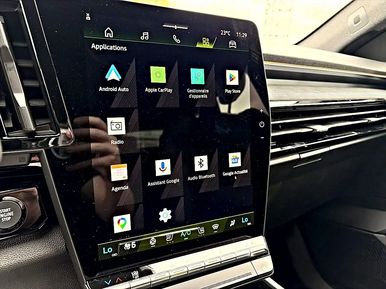 Écran tactile central en gros plan à l'intérieur du Renault Austral gris schiste, affichant les applications connectées.