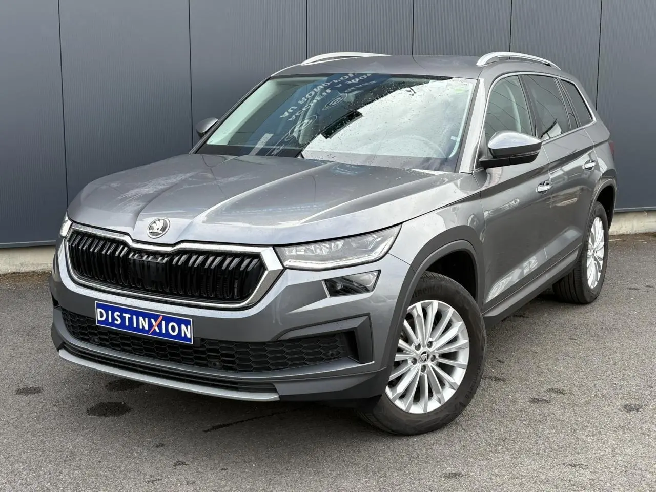 SKODA KODIAQ gris graphite vu en 3/4 avant droit, avec calandre noire et jantes alliage 18 pouces.