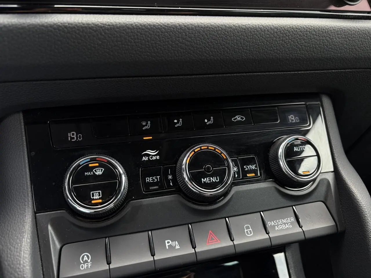 Gros plan sur la console de climatisation automatique bi-zone du Skoda Kodiaq gris graphite, avec commandes rotatives et affichage digital.