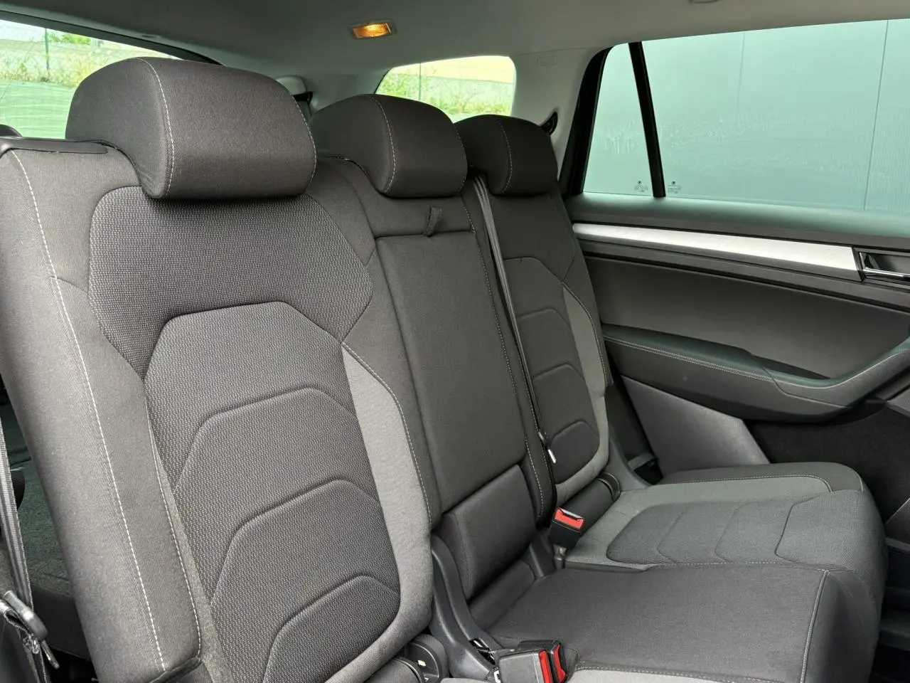 Vue intérieure côté droit des sièges arrière en tissu gris foncé du Skoda Kodiaq 2024 version Ambition 7 places.