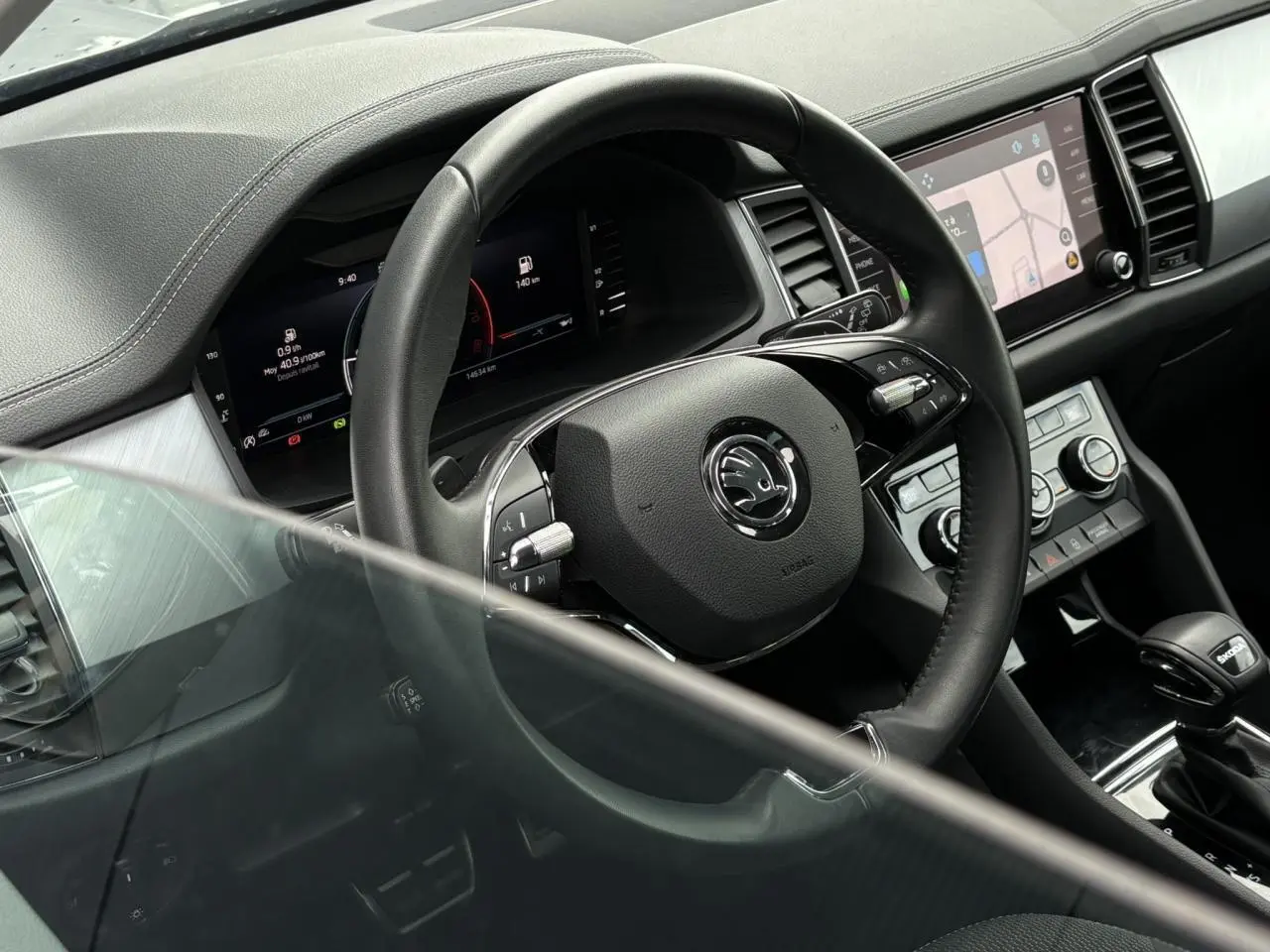 Vue intérieure rapprochée du volant et du tableau de bord numérique du Skoda Kodiaq 2024 avec console centrale et écran tactile.