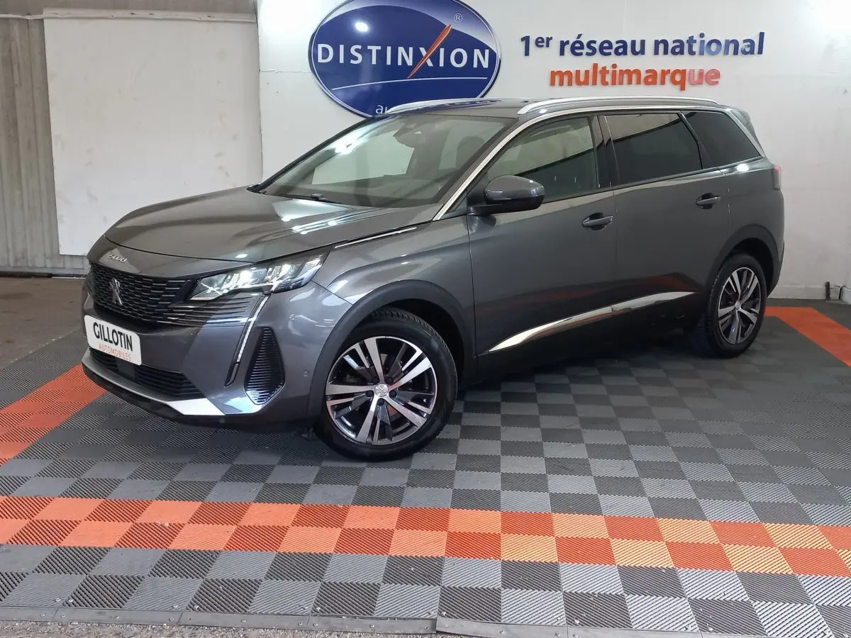 Peugeot 5008 gris foncé en 3/4 avant droit, mettant en valeur ses lignes modernes et ses jantes alliage.