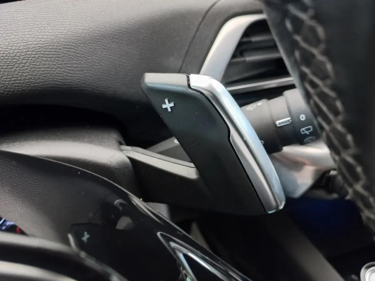 Gros plan sur la palette de changement de vitesse + côté droit du volant cuir du Peugeot 5008 gris foncé 2021.