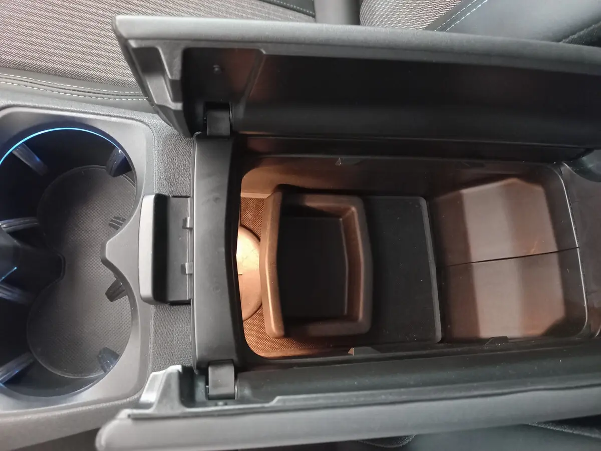 Vue rapprochée de la console centrale ouverte avec rangement et porte-gobelets du Peugeot 5008 gris foncé 2021 Allure Pack.