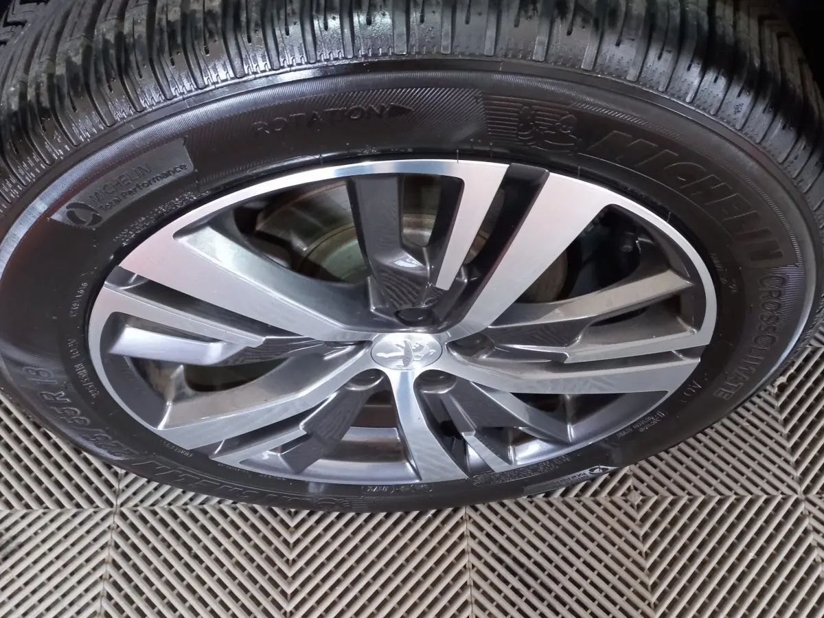 Gros plan sur la jante alliage argentée et noire du Peugeot 5008 gris foncé, pneu Michelin CrossClimate visible.