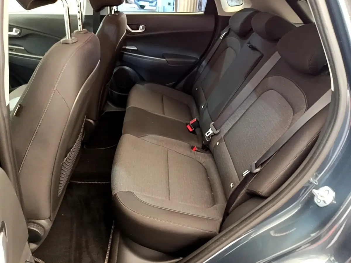 Vue côté gauche arrière montrant la banquette trois places en tissu gris du Hyundai Kona bleu électrique 2023.