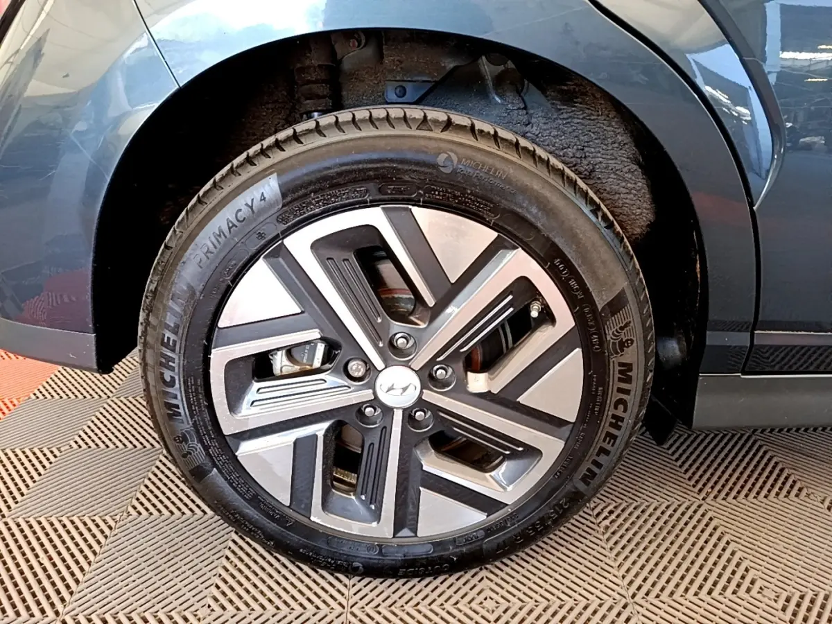 Gros plan sur la roue avant gauche de la Hyundai Kona électrique bleue, avec jante alliage et pneu Michelin.