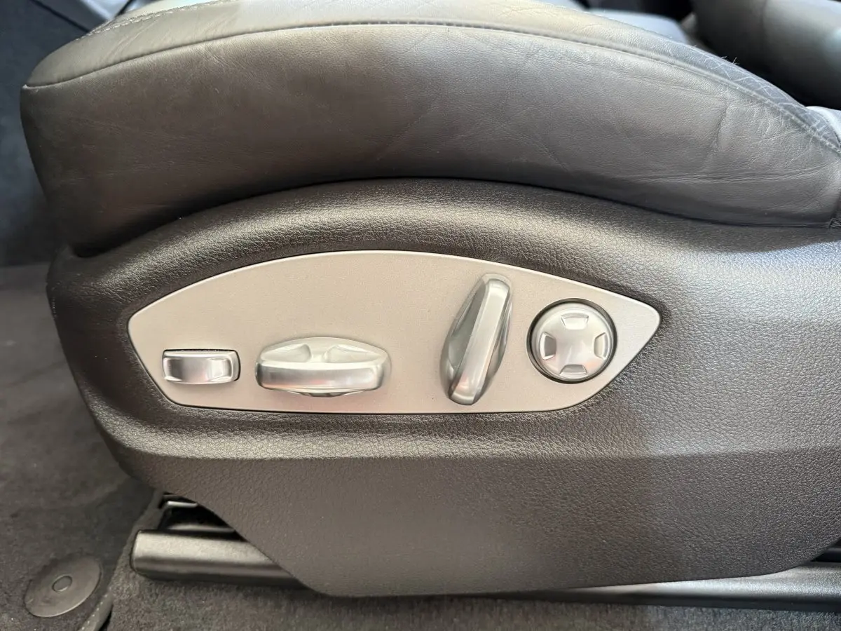 Gros plan sur les commandes de réglage électrique du siège en cuir noir du Porsche Macan 3.0 S gris foncé.