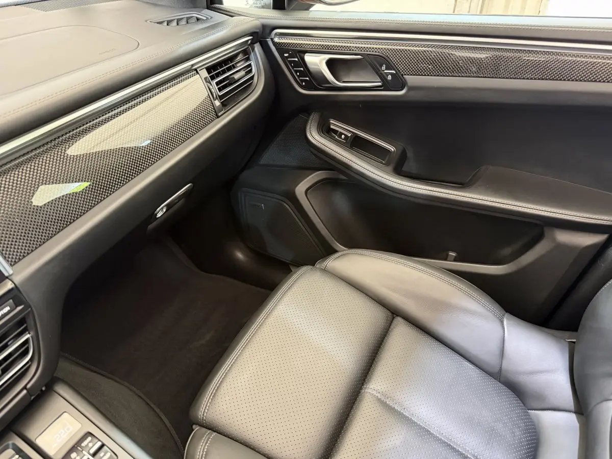 Intérieur côté passager du Porsche Macan 3.0 S 2019, cuir noir et inserts carbone sur tableau de bord et porte.