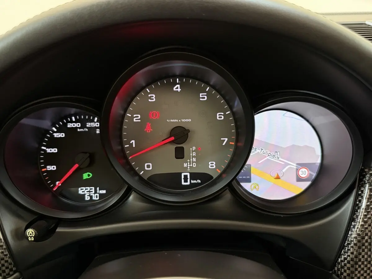 Vue rapprochée du tableau de bord du Porsche Macan 3.0 S 2019, affichage numérique et compteur tachymètre central.