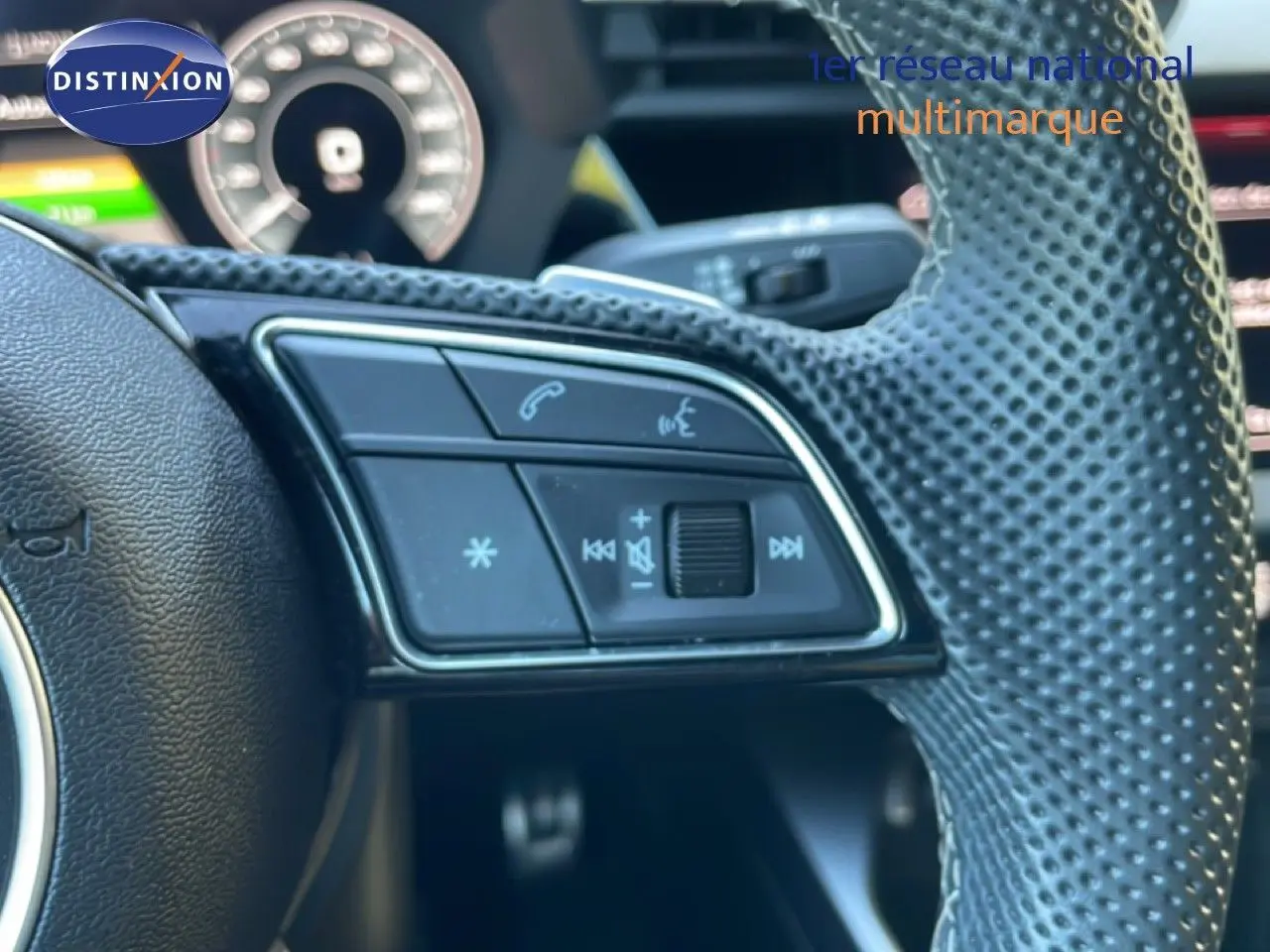 Gros plan sur les commandes gauche du volant perforé noir de l'Audi A3 Sportback 40 TFSIe 2025 hybride rechargeable.
