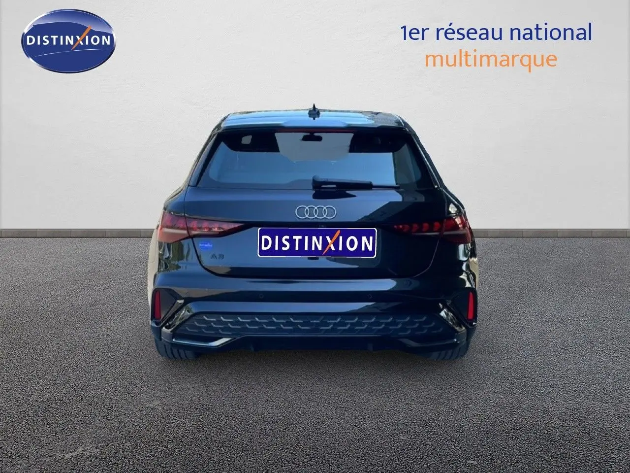 Vue arrière d'une Audi A3 Sportback noire Mito Metal 2025 avec feux LED et logo distinctif sur fond neutre.