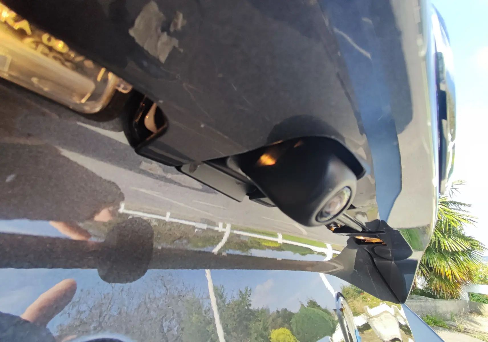 Gros plan sur la caméra de recul sous le hayon arrière d'une Mazda2 gris foncé 2024.