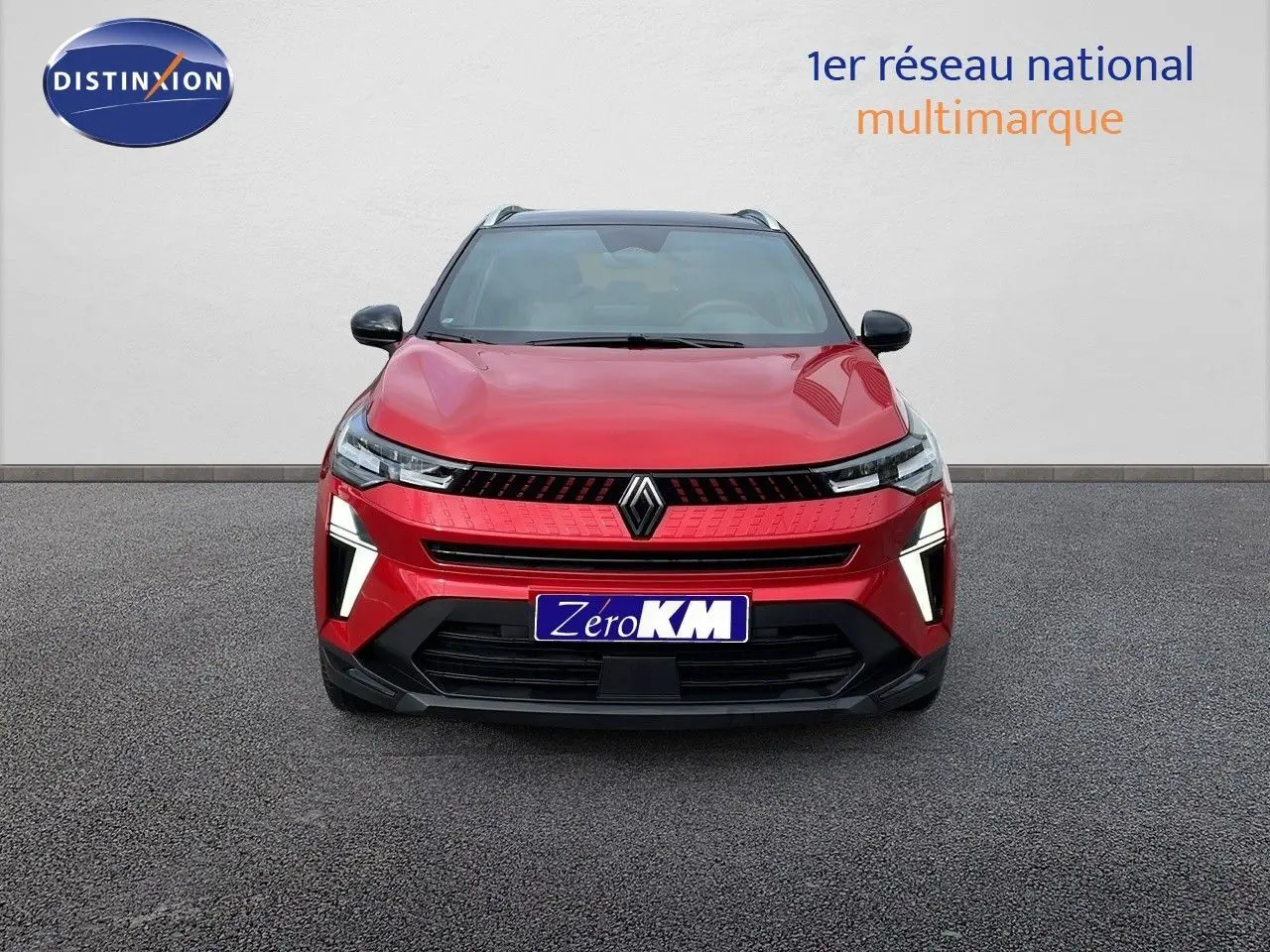 Vue frontale d'un Renault Captur E-Tech hybride rouge passion avec toit noir et éclairage LED distinctif.