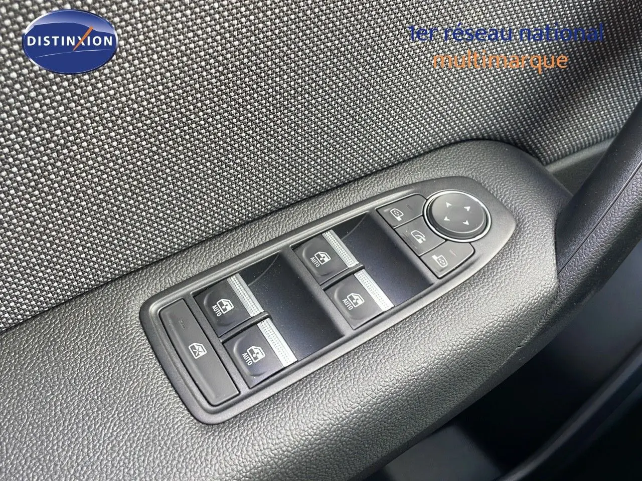 Commande des vitres électriques et réglage des rétroviseurs sur la porte côté conducteur d'un Renault Captur rouge 2025.