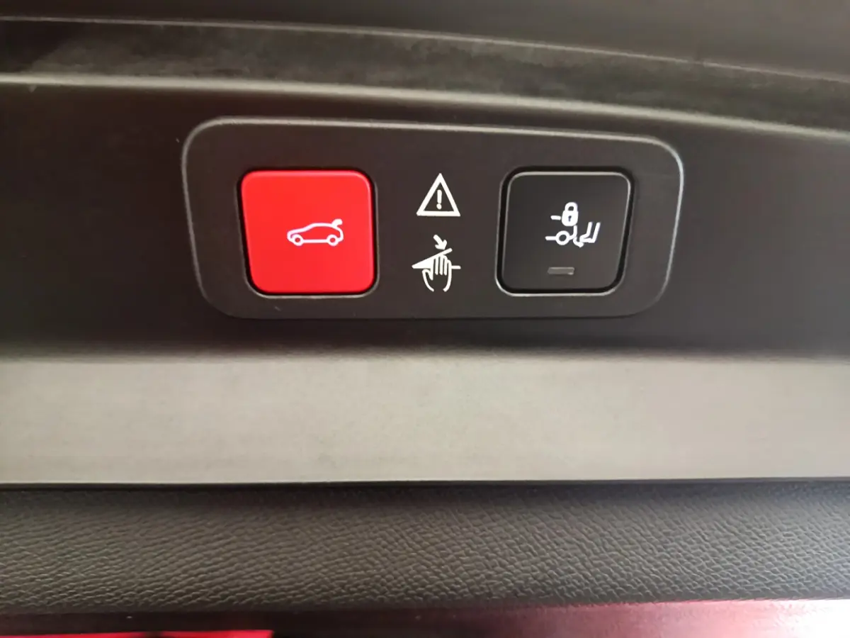 Gros plan sur les boutons de commande de coffre et verrouillage des sièges arrière du Peugeot 5008 GT bleu.