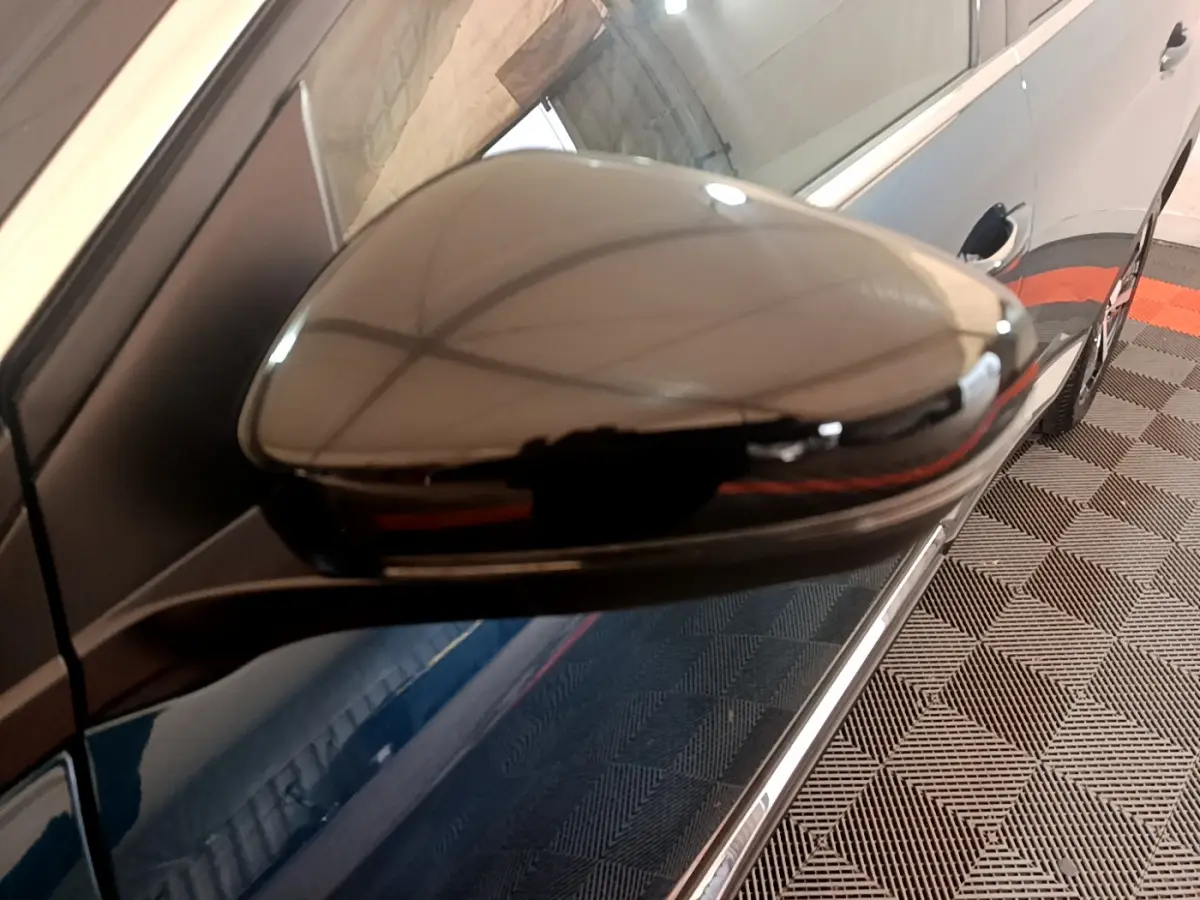 Rétroviseur droit noir brillant du Peugeot 5008 bleu, vue rapprochée côté droit avec reflet intérieur.