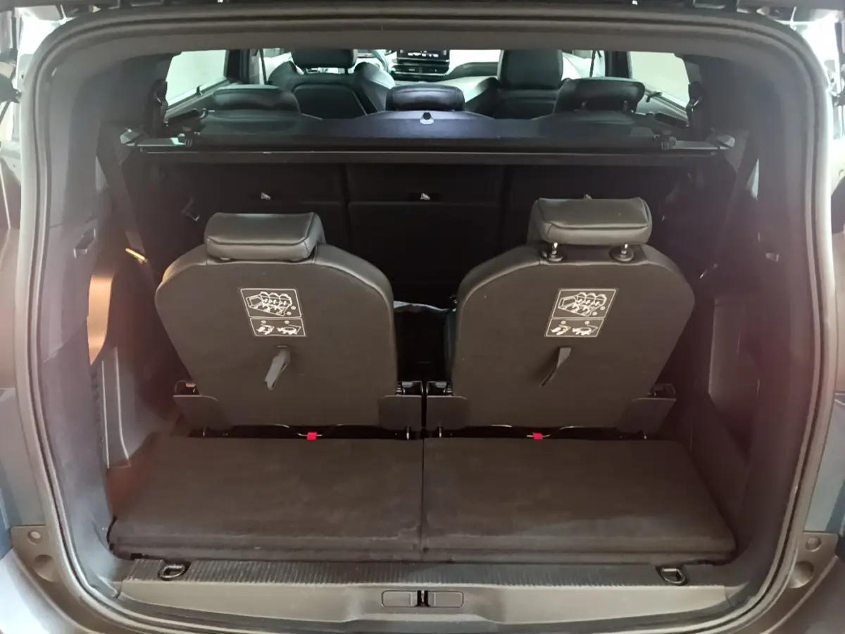 Vue arrière du coffre du Peugeot 5008 bleu, montrant la 3ème rangée de sièges individuels rabattus et amovibles.