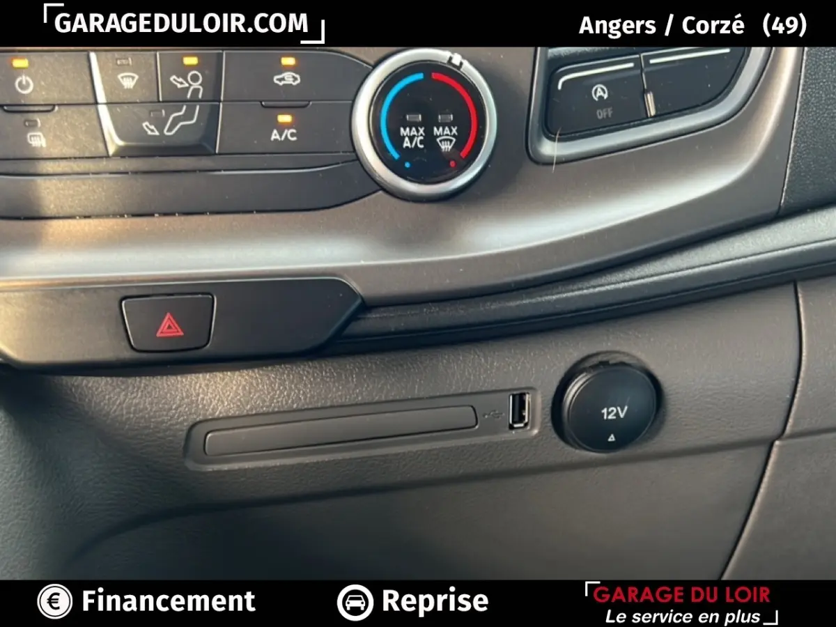 Détail de la console centrale avec commandes climatisation et prise 12V du Ford Transit Custom blanc 2023.