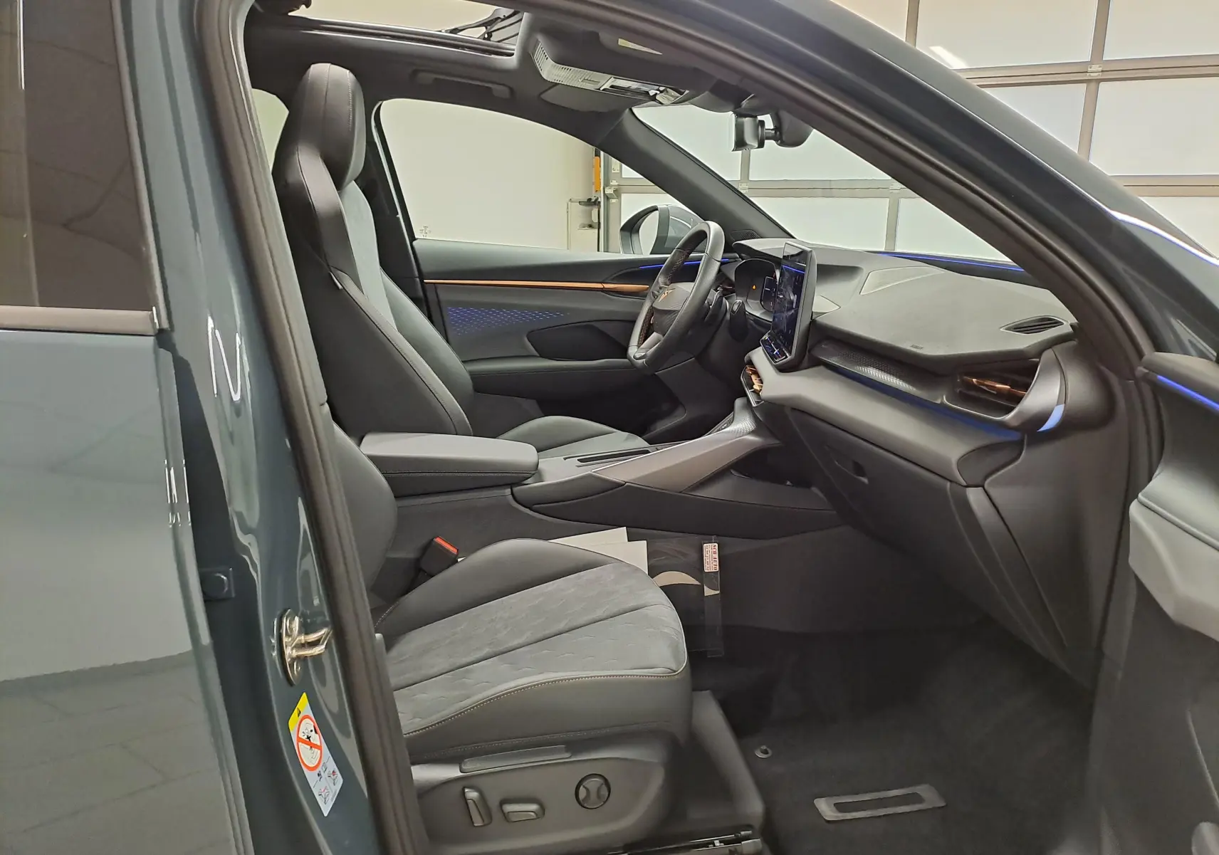 Intérieur côté conducteur de la CUPRA TERRAMAR bleu Fjord 2025 avec toit ouvrant panoramique et sièges en cuir noir.