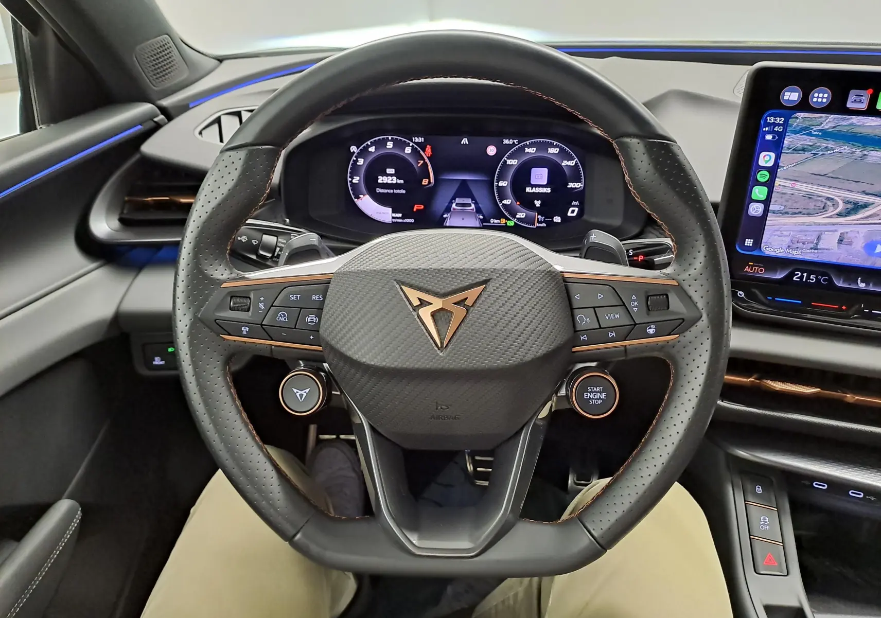 Vue intérieure centrée sur le volant perforé du CUPRA TERRAMAR 2025 avec tableau de bord numérique et écran tactile latéral.