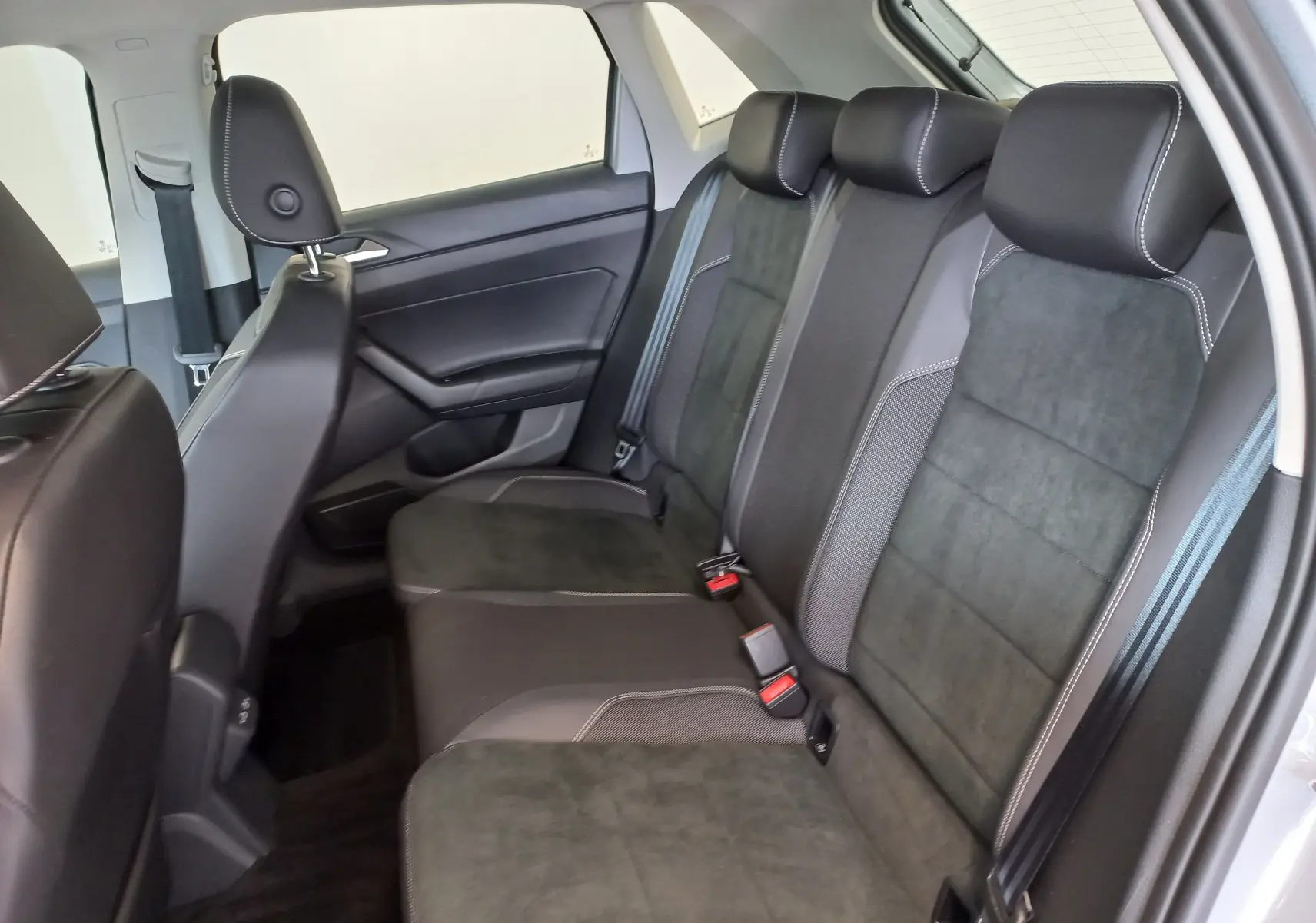 Vue intérieure des sièges arrière noirs avec surpiqûres blanches de la Volkswagen Polo 2026 couleur Reflet d'Argent, côté droit.
