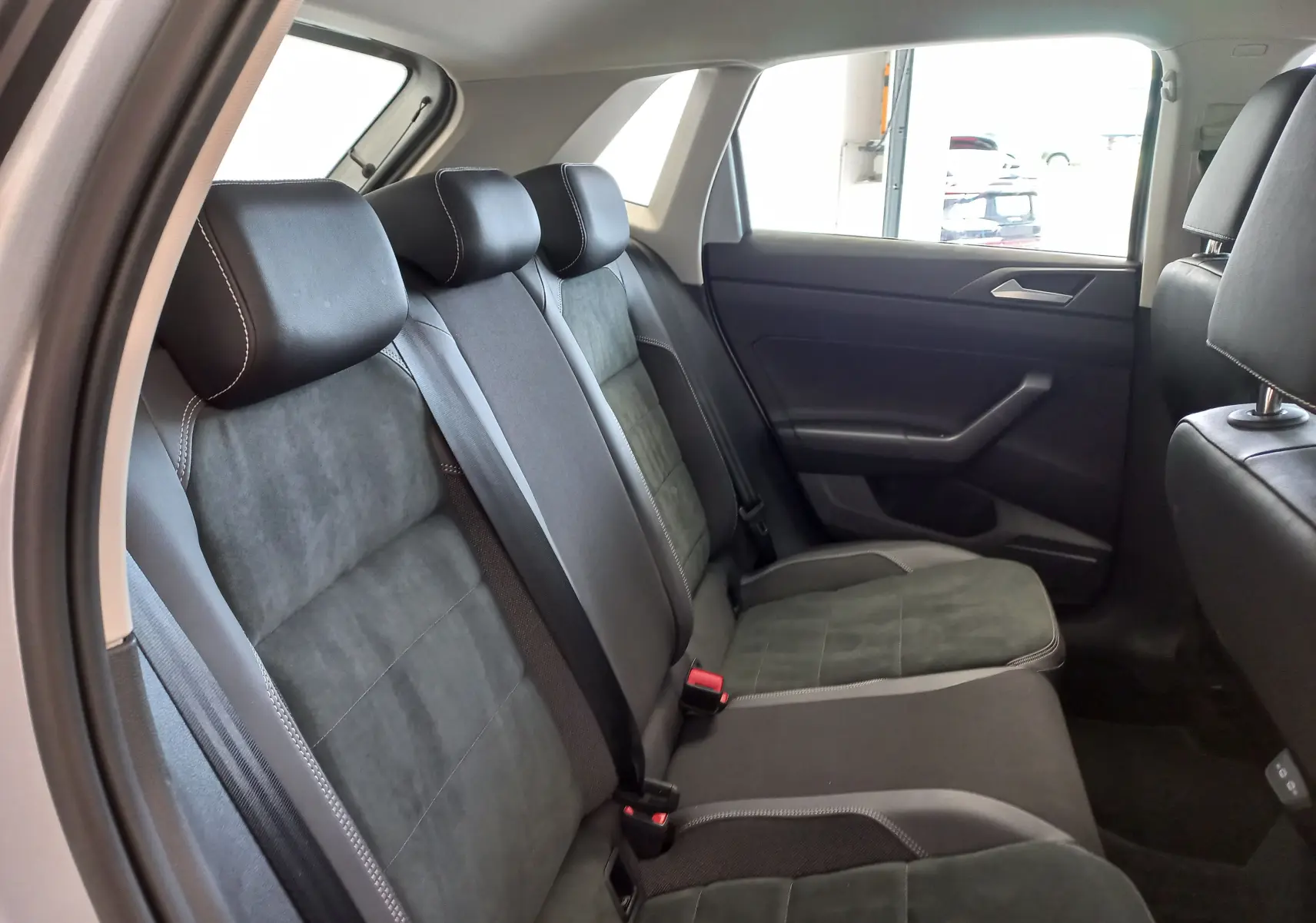 Vue intérieure côté gauche des sièges arrière en tissu noir avec surpiqûres blanches de la Volkswagen Polo 1.0 TSI 95 DSG7 Style 2026.