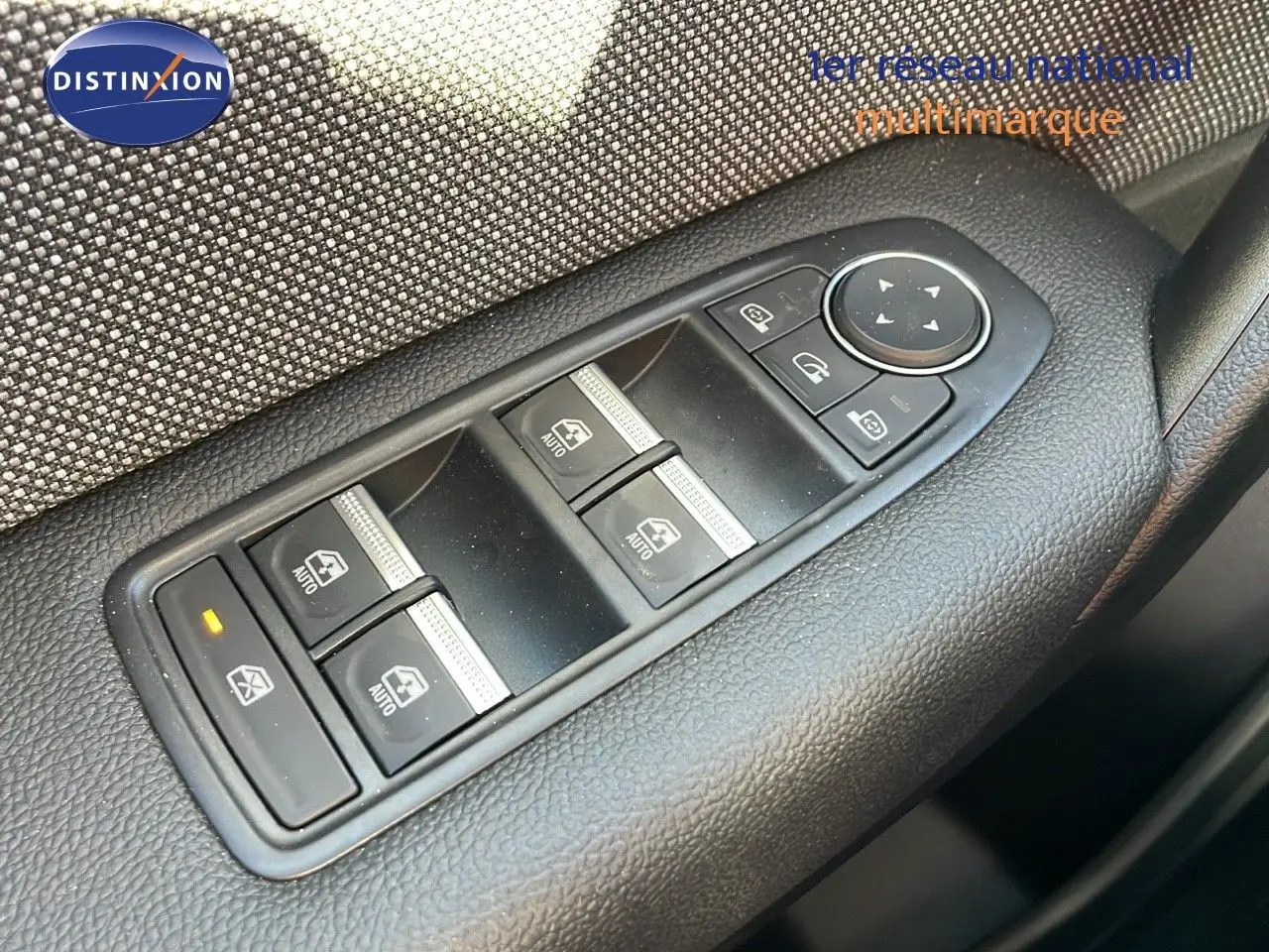 Gros plan sur les commandes des vitres électriques côté gauche d'un Renault Captur gris Rafale métal toit noir 2025.