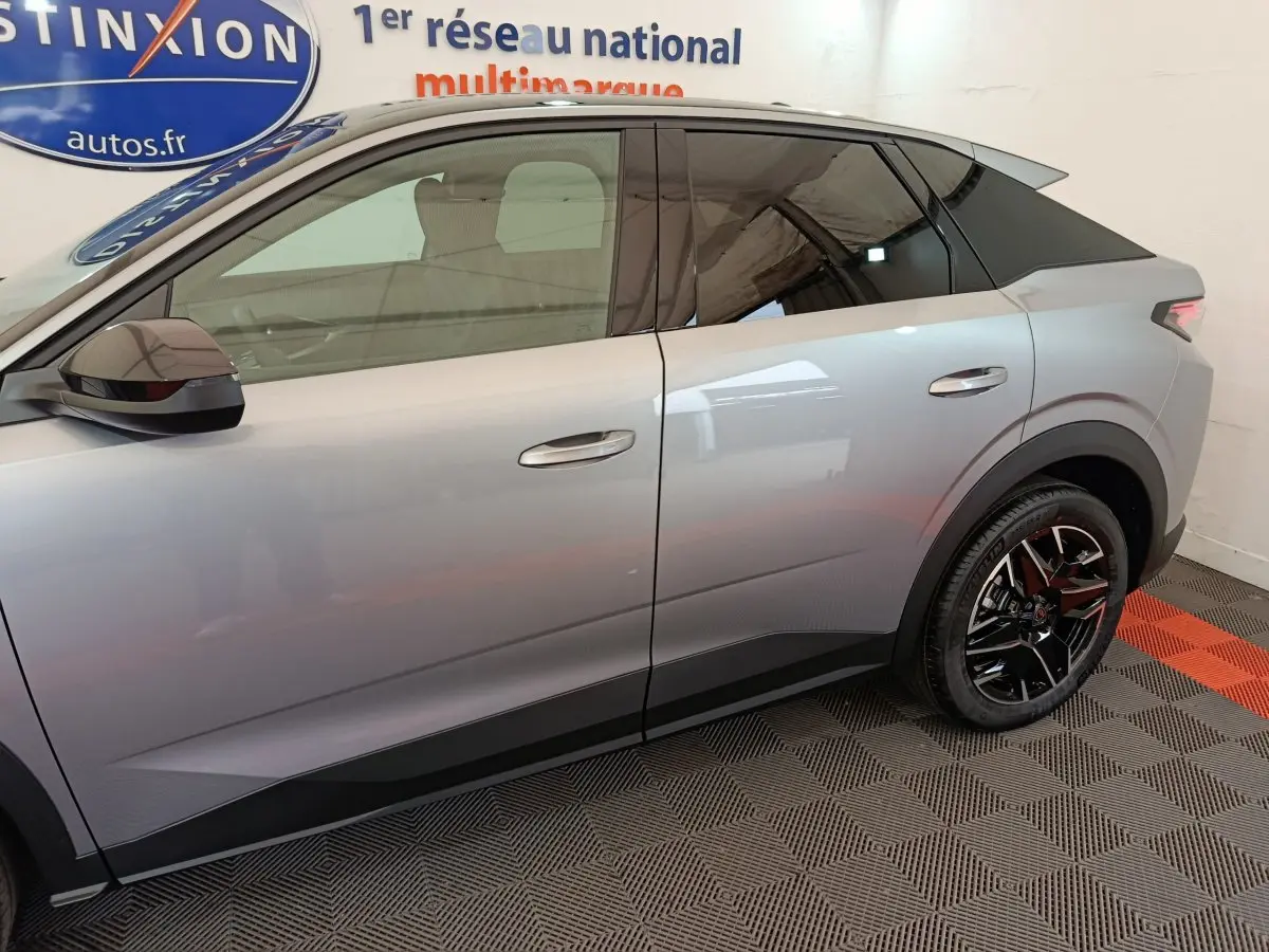 Profil côté gauche du Peugeot 3008 gris clair 2025 avec jantes noires et toit noir contrasté.