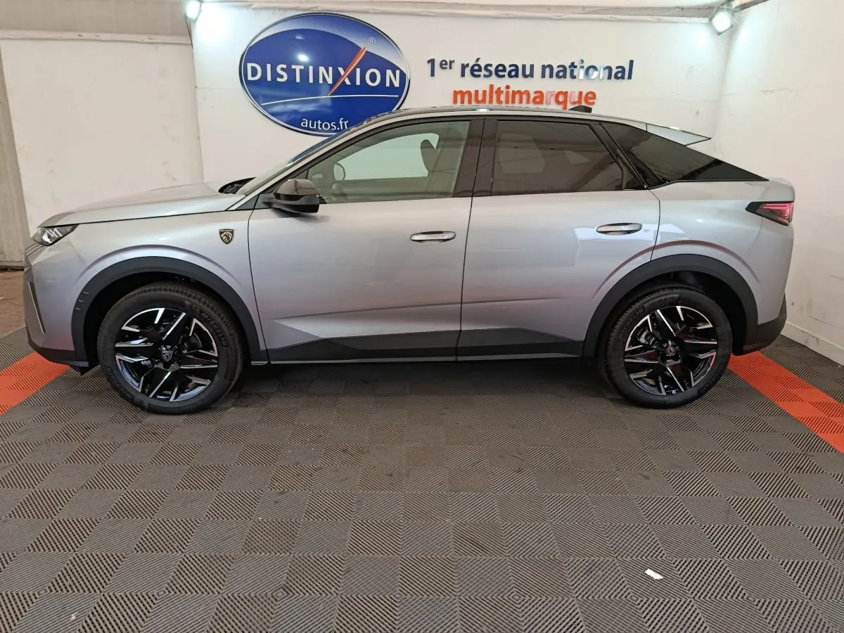 Profil côté gauche d'un Peugeot 3008 gris clair 2025 avec jantes noires et toit noir dans un showroom