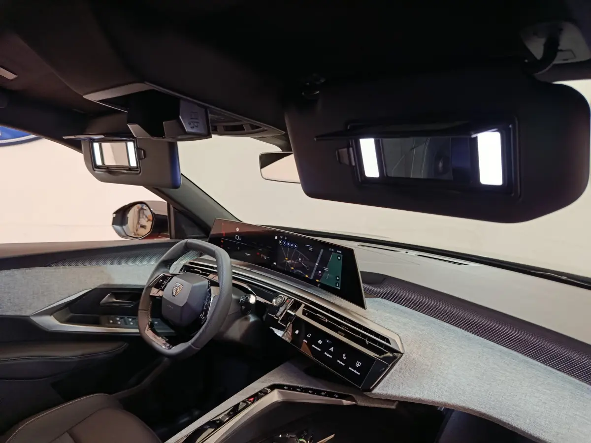 Intérieur du Peugeot 3008 1.2 Hybrid 145 GT 2025, tableau de bord moderne gris clair avec écran tactile panoramique.