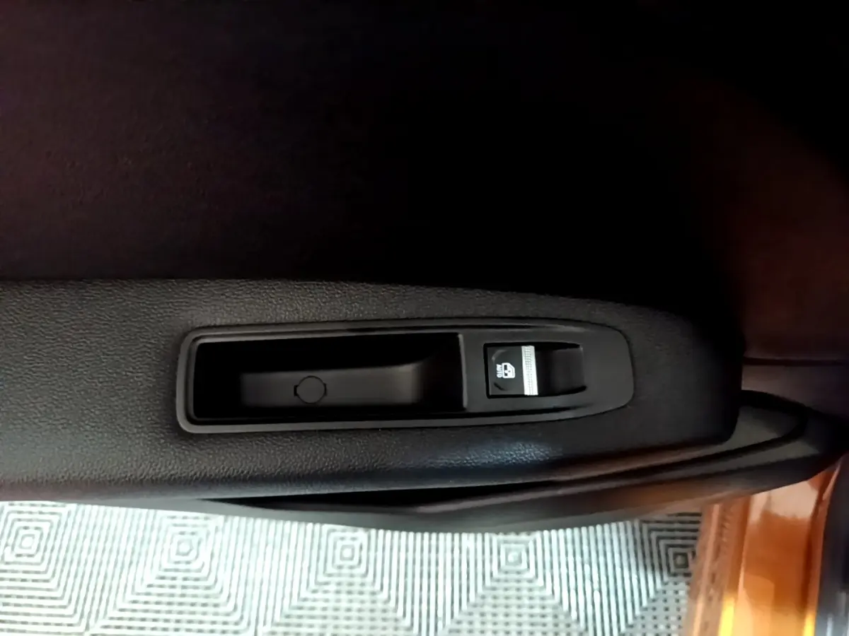 Gros plan sur le bouton de verrouillage des portes côté intérieur d'une Renault Captur jaune, version Intens 2020.