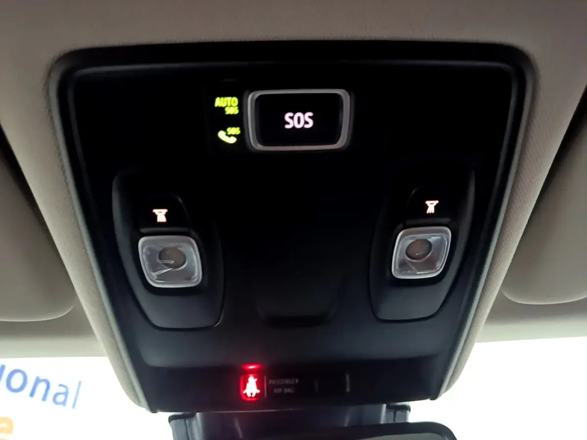 Vue en contre-plongée du plafonnier intérieur noir avec boutons d’éclairage et alerte SOS allumée dans un Renault Captur jaune.