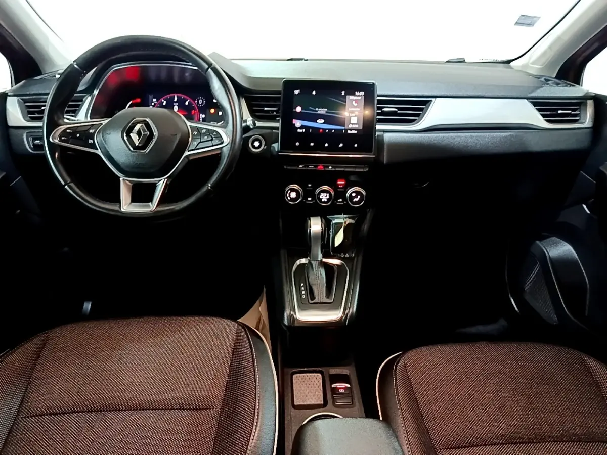 Vue intérieure avant du Renault Captur Intens 2020, tableau de bord noir avec écran tactile central et volant cuir multifonctions.